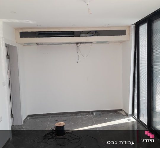 חדר עם קיר גבס פתוח וחוטים חשמליים